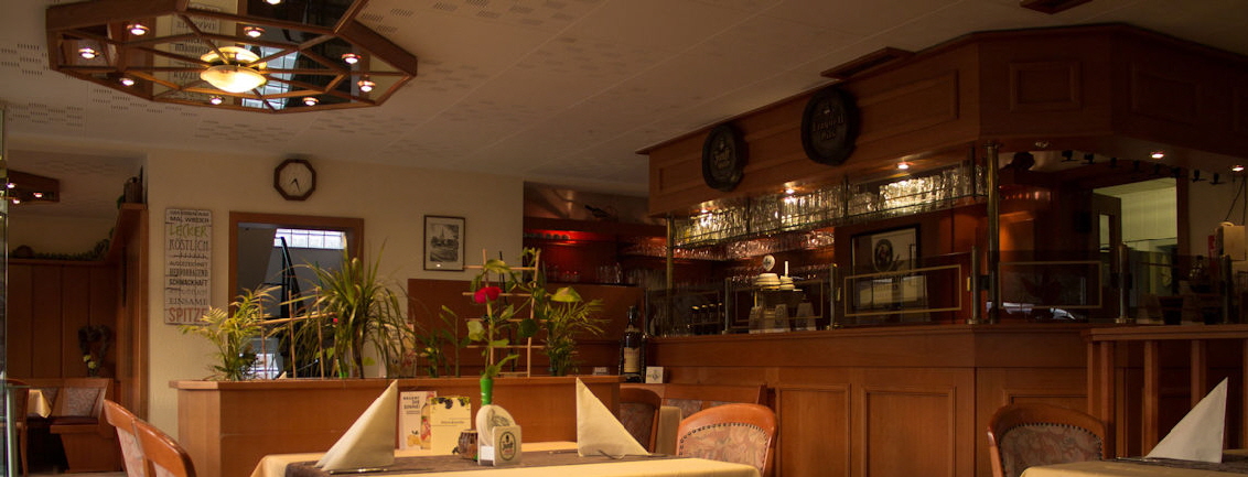 Innenraum des Restaurant Dionysos mit gedeckten Tischen und Barbereich